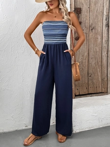 Detail of strapless navy jumpsuit featuring elastic waist and striped bodice design