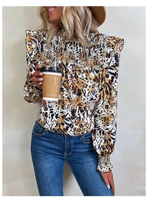 Detail of smocked neckline and leopard print fabric on a stylish long sleeve blouse