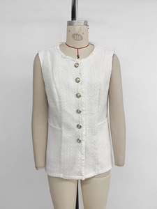 Close-up of white tweed vest featuring gold embossed buttons and fringe detail trim