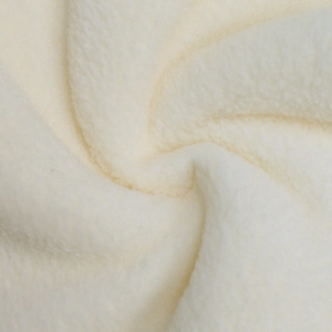 Macro shot of soft beige fleece texture showing thick plush fabric of the winter cardigan