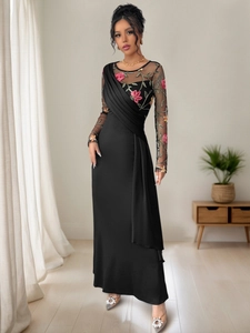Detailed embroidery on mesh sleeves and pleated bodice of a black evening gown