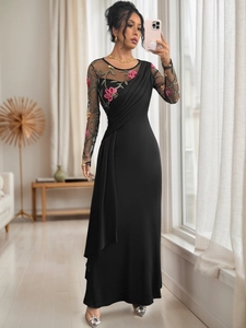 Close-up of elegant mesh long sleeves with red floral embroidery and ruched dress details