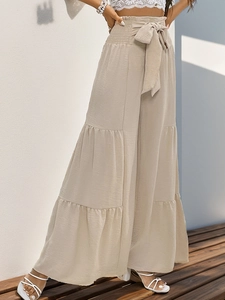 Detail of high waisted tiered wide leg pants with elastic waist and fabric bow tie