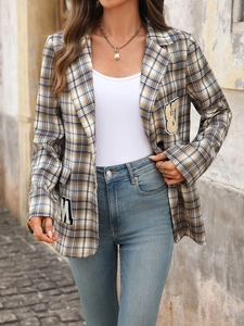 Detail eines Vintage-Karojackets mit Wolltextur und dekorativen College-Buchstaben-Patches