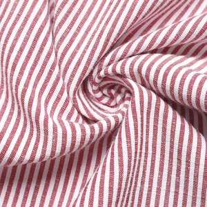 Close-up of red and white striped fabric with natural cotton-linen texture and soft drape