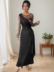 Detail of elegant black mesh long sleeve with colorful floral embroidery and pleated waist