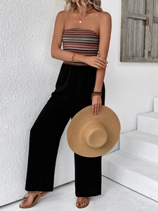 Detail of colorful striped knit bodice and high-waist black wide-leg jumpsuit