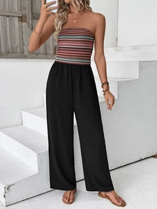 Detail of colorful striped bandeau top and black high-waisted wide leg jumpsuit