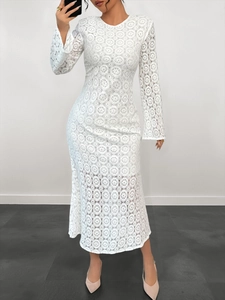 Dettaglio del ricamo in pizzo bianco su abito bohémien elegante a maniche lunghe