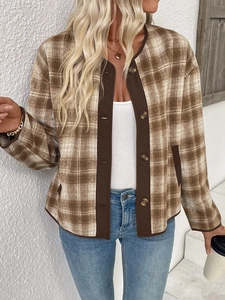 Dettaglio del cardigan a quadri marroni con bottoni dorati e maglia a trama fitta