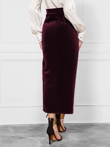 Rear view of a burgundy velvet midi skirt with high waist and elegant slit detail