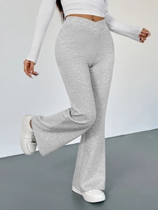 Detail of light grey flare pants featuring a V-shaped crossover waist and smooth texture