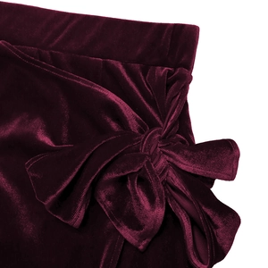 Detail of burgundy velvet fabric with elegant knot design and shimmering texture