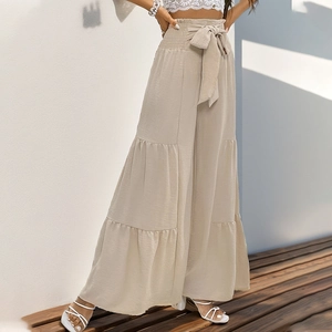 High-waisted beige wide-leg trousers with bow tie and tiered ruffles in pleated fabric