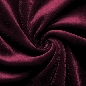 Detailed macro view of premium burgundy velvet fabric texture and soft luster folds