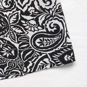 Macro-opname van zwart-witte paisley bloemenprint op de stof van een elegante lange jurk