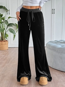 Detail view of high waisted velvet trousers featuring a grey elastic drawstring waistband