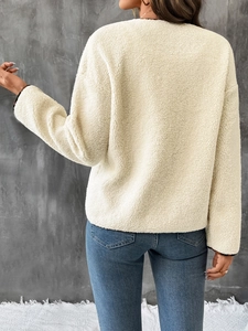 Detail of plush off-white fleece jacket texture with long sleeves and soft tactile finish