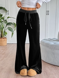Detail shot of black velvet high-waisted trousers with adjustable drawstring waistband