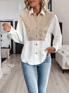 Close-up of white shirt with gold sequin V-pattern and metallic button detail