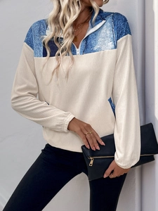 Détail d'un sweat bicolore avec col à demi-zip et contraste de texture en velours côtelé