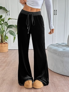Detail view of black velvet wide-leg trousers with high-waist drawstring and soft texture