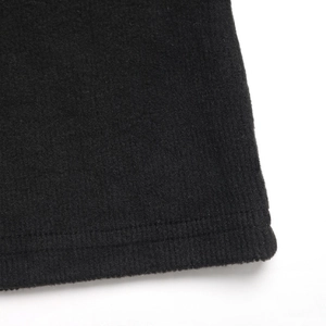 Vue détaillée du tricot côtelé noir avec finition d'ourlet à double couture professionnelle