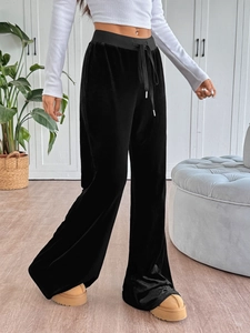 Detailed macro view of black velvet flare trousers with adjustable elastic drawstring waist