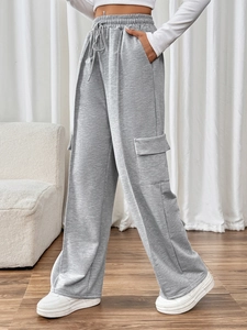 Detail view of high waist drawstring grey cargo pants with side pockets in wide leg style