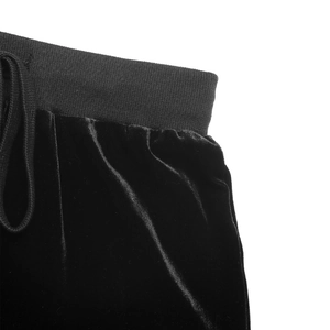 Detail view of the black velvet pants featuring elastic ribbed waistband and drawstring cord