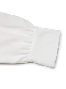 Detailed close-up of gathered cuffs on white sequined long sleeve blouse for women