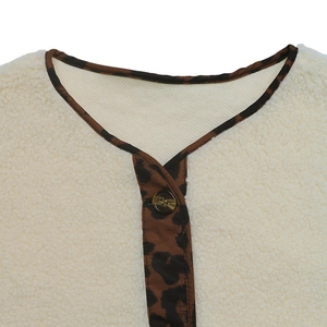 Close-up of fluffy white fleece collar with leopard print trim and a resin button