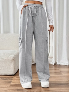 Detailed view of elastic high waist and functional flap pockets on light grey cargo pants