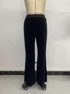 Detail of the elastic high waist on black velvet flared pants with a smooth drape texture
