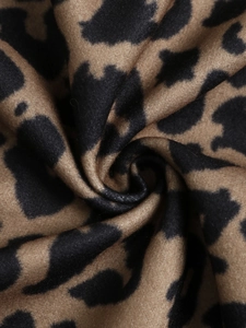 Close-up of leopard print fabric texture showing soft brown and black faux fur details