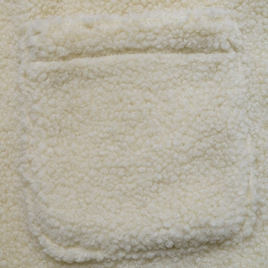 Macro shot of cream sherpa fleece fabric detail and sewn pocket on the women jacket