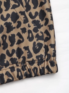 Detail view of leopard print jacket with textured fabric, side pocket, and elastic hem