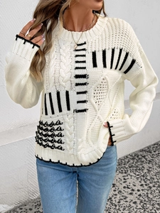 Dettagli della trama a maglia a trecce e strisce nere sul maglione bianco a girocollo