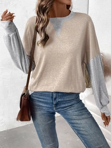 Detail of female casual patchwork top with khaki body and light grey ribbed sleeves