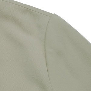 Macro shot of precise shoulder seam stitching on minimalist light khaki blazer