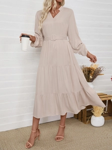 Close-up of the elegant V-neck and belted waist of this solid color long sleeve dress