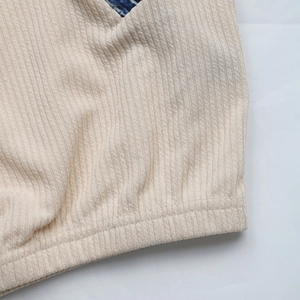 Gros plan sur la texture du tissu côtelé et les coutures d'un sweat-shirt beige femme