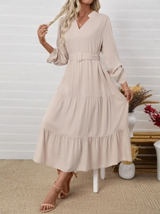 Detail view of beige tiered maxi dress with V-neckline and matching waist belt