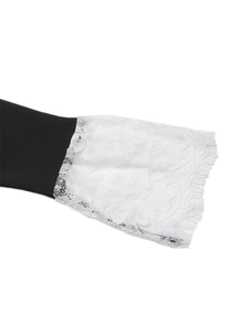 Détail d'une manche de robe noire avec dentelle florale blanche raffinée et bordure en cils