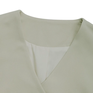 Detail shot showing the V-neckline structure and mint green textured fabric of the blazer