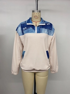 Détail du sweat-shirt color-block avec tissu beige côtelé et imprimé denim aux épaules