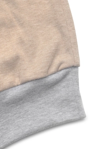 Detailed close-up showing stitching and grey patchwork hem on oatmeal knit sweatshirt