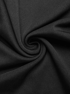 Vue macro montrant la texture du tissu noir haute densité et le drapé lisse de la robe