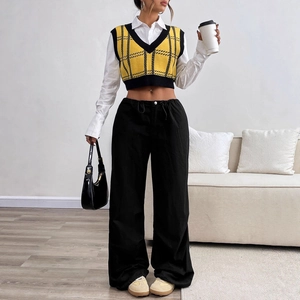 Women's V-neck plaid knit vest layered with white shirt and black wide-leg trousers