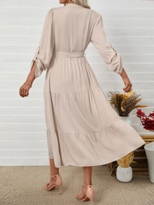 Detail view of champagne maxi dress showing multi-layer skirt and adjustable long sleeves
